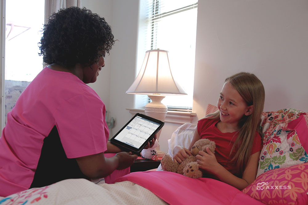 Pediatrics nurse reviewing a patient's chart on an iPad.
