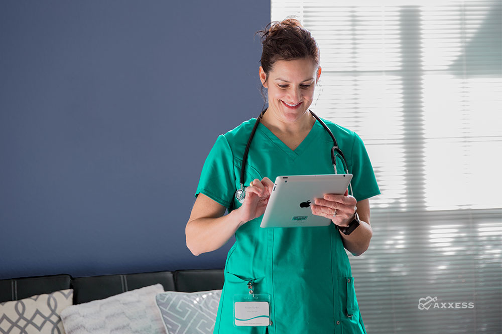 Happy home care provider in a living room viewing her iPad