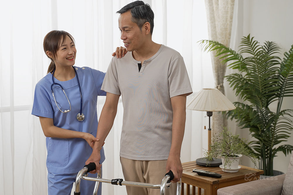 A female clinician helps a male patient standing and holding a walker
