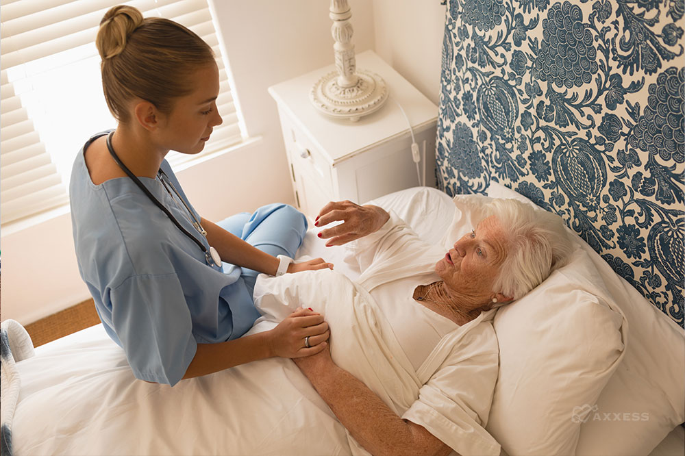 Compassionate home healthcare: A young nurse provides care and comfort to a senior woman in her bed. Geriatric care, senior care, elderly care, home health aide.