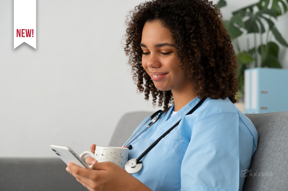 Healthcare professional in scrubs sitting on a couch, holding a mug and looking at a smartphone.
